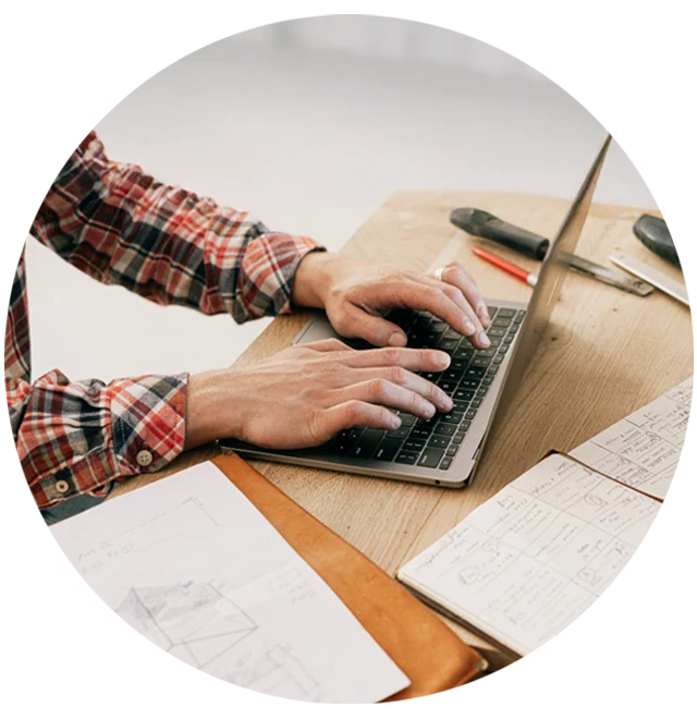 Person Using Macbook Pro On Brown Wooden Table